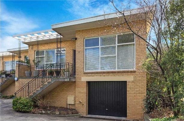 This property features a stylish brick exterior, large windows, and a spacious garage, perfect for family living in Surrey Hills.